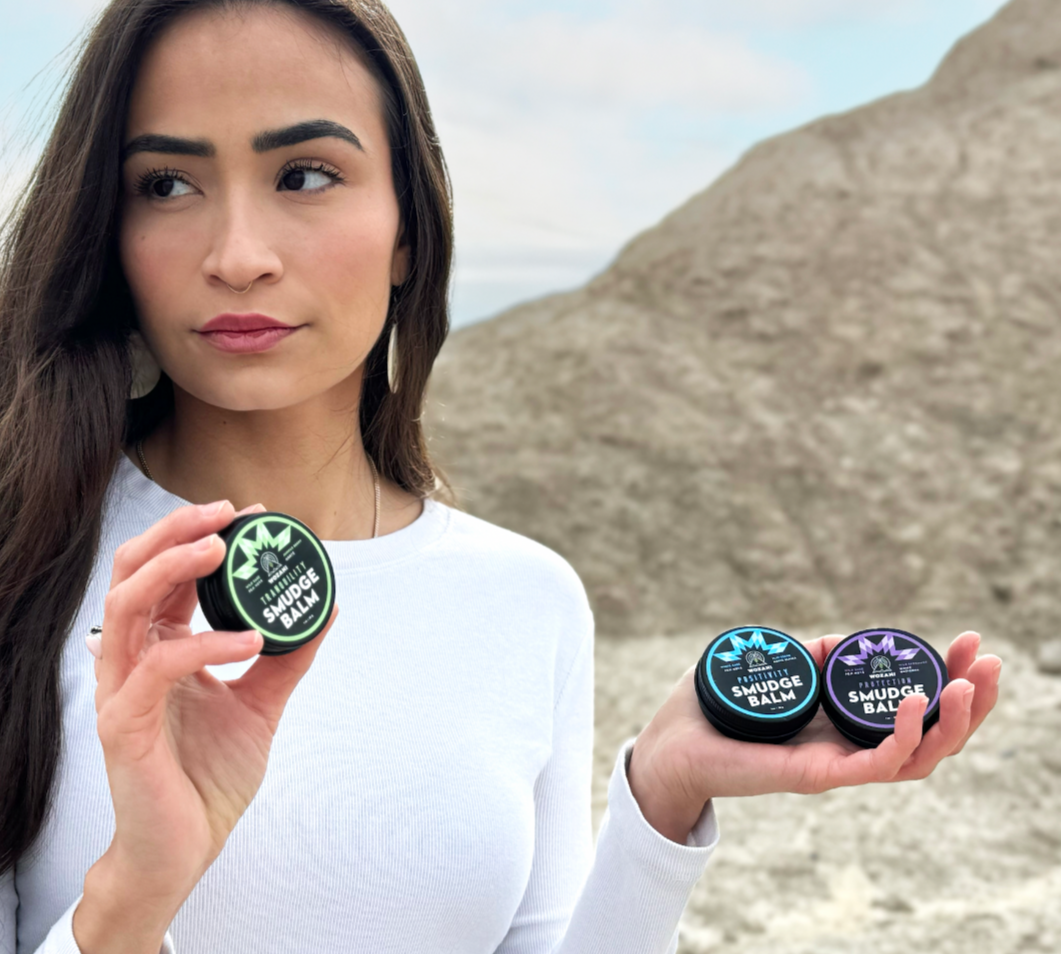 Beautiful native american girl holding wozani smudge balms used for protection and positivity made with essential oils
